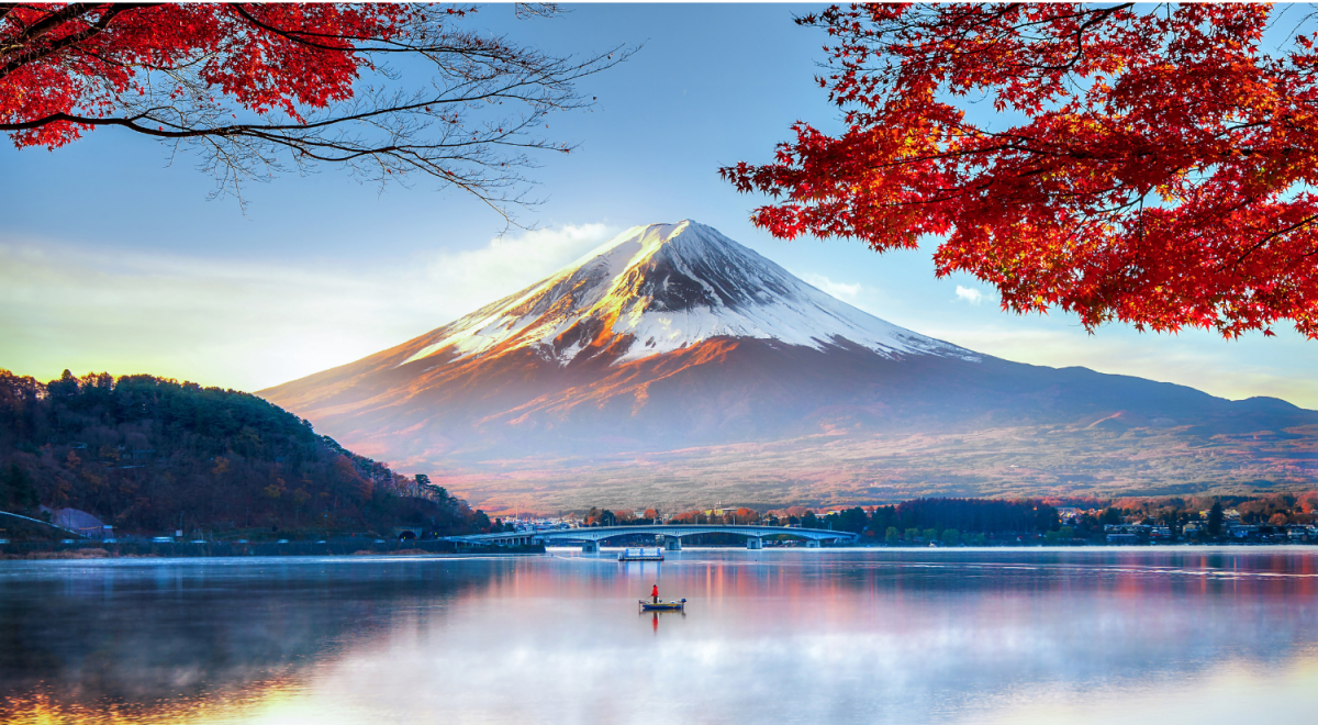 Autumn leaves frame Mount Fuji over a lake