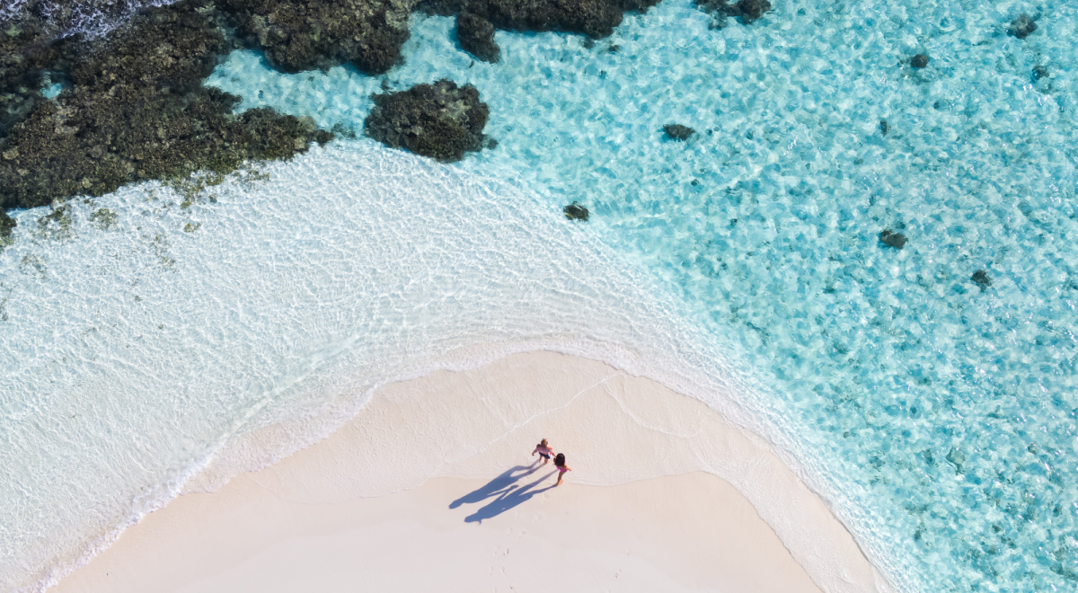 Drone shot of a couple walking in the Maldives.