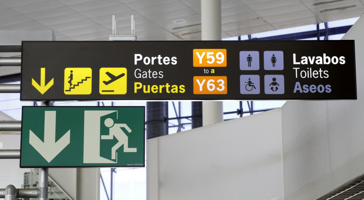 A sign with text in Spanish at an airport