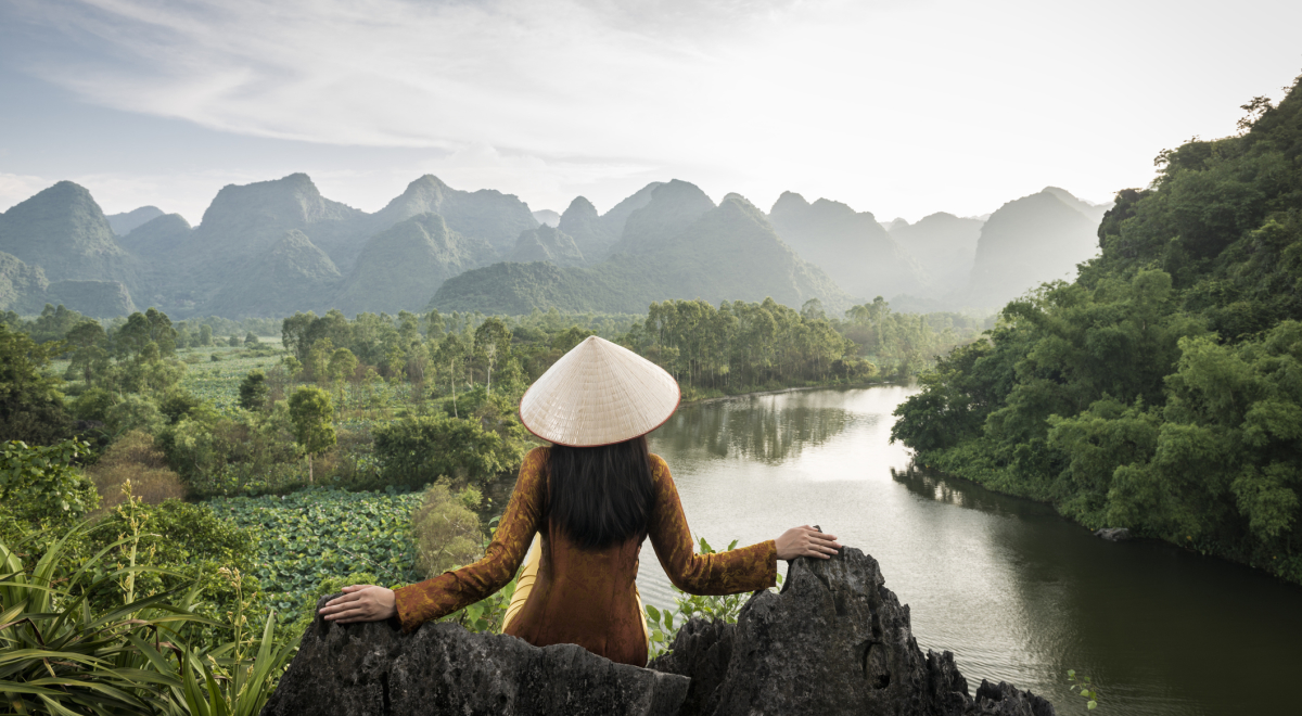 Vietnamese woman on hilltop in front of mountains