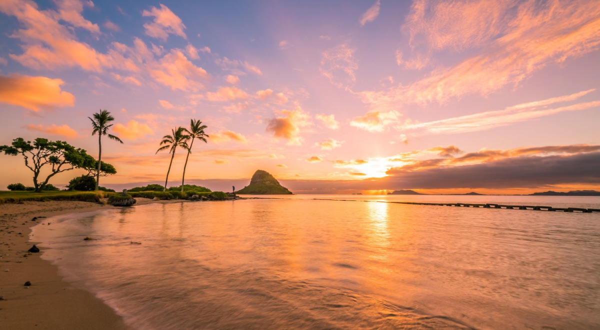 The sun setting over a beach in Hawaii