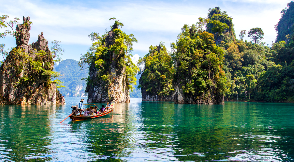 Clear blue waters surrounded by trees in Khao Sok National Park, Thailand.
