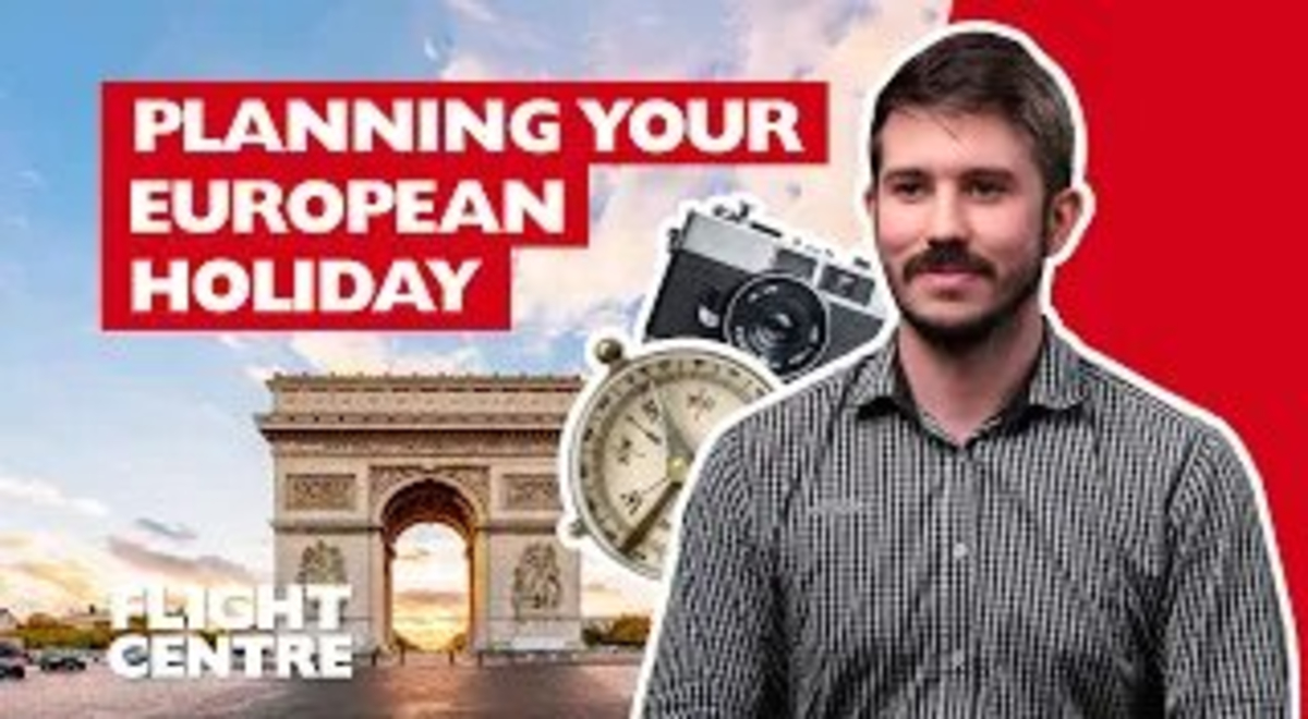Man sitting down next to a clock, camera and Arc de Triomphe