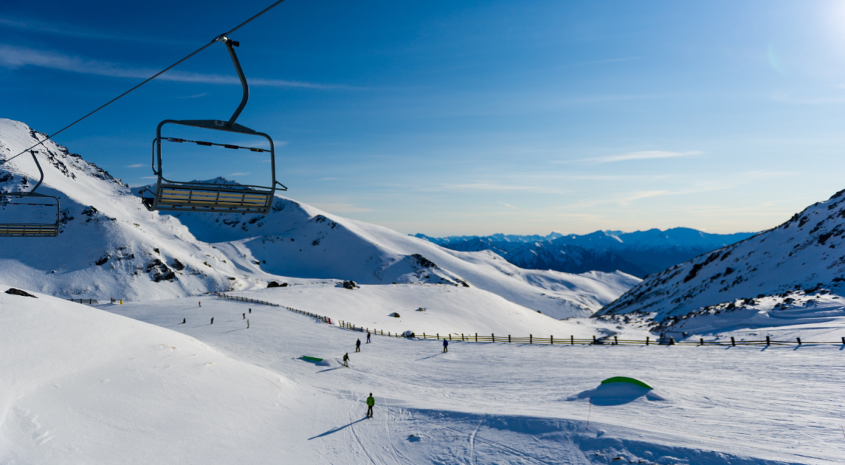 Ski slopes and snowy mountains with ski lift in foreground 
