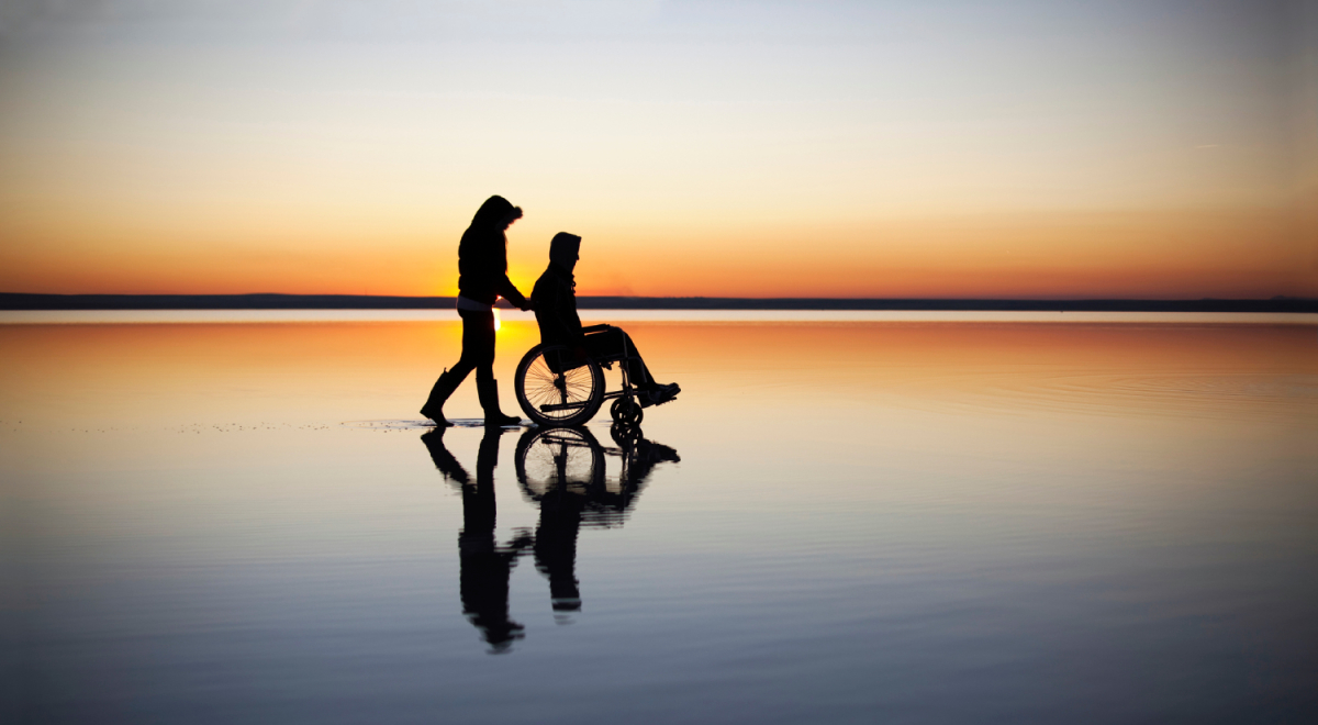 Wheelchair on beach at sunset