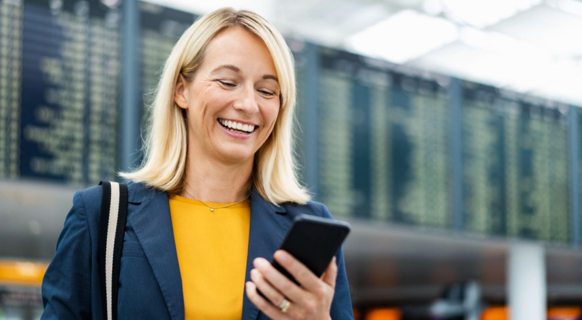lady in airport smiling at phone