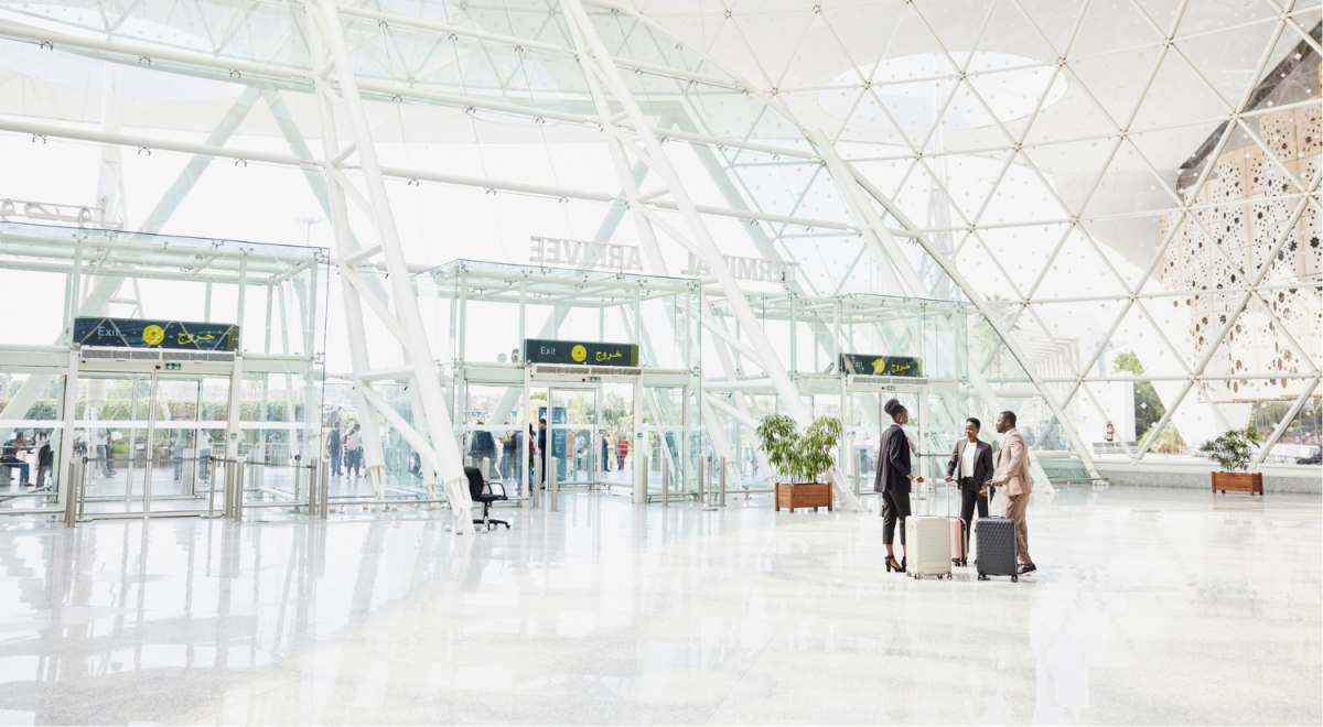 three business people with suitcases standing at airport
