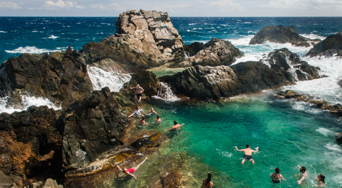 Travellers swimming in the Conchi natural pool in Aruba