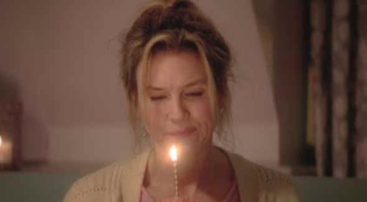 Woman holding a cupcake with a candle light 