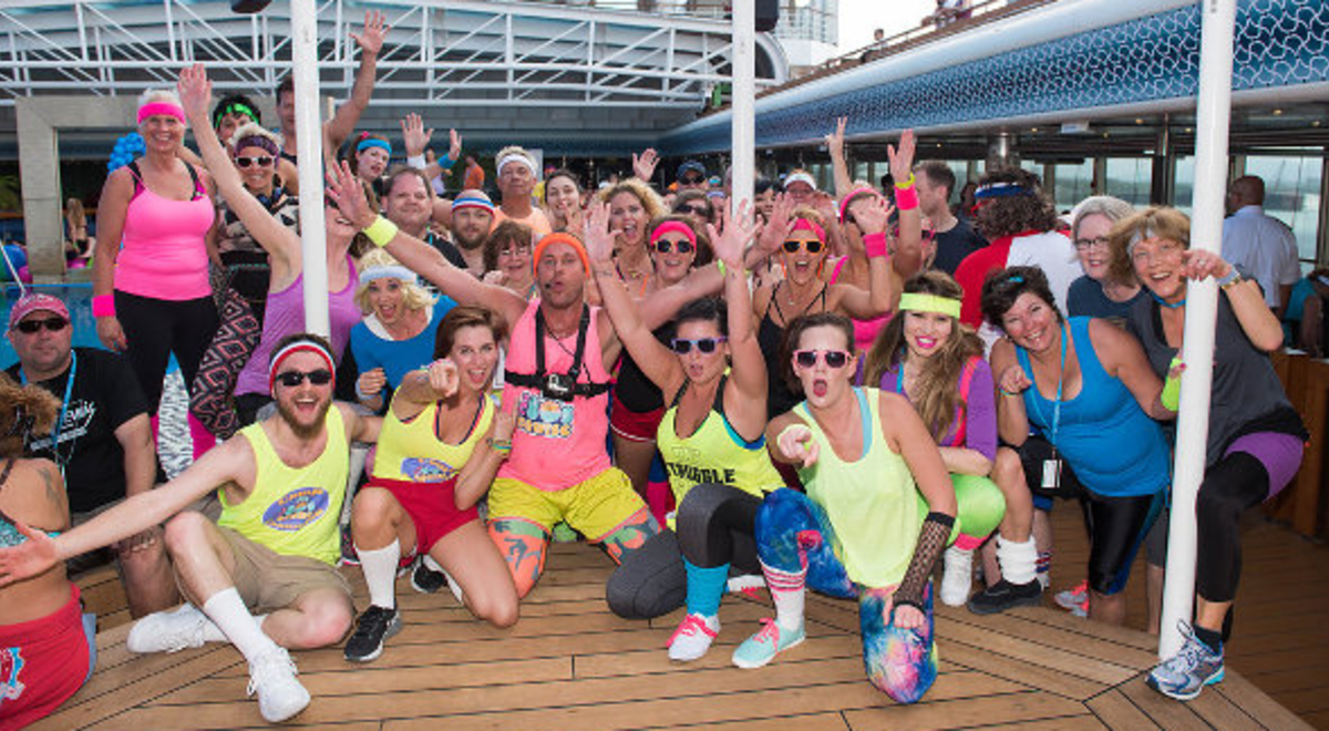 a group of people in their colorful 80s workout outfits on a cruise ship