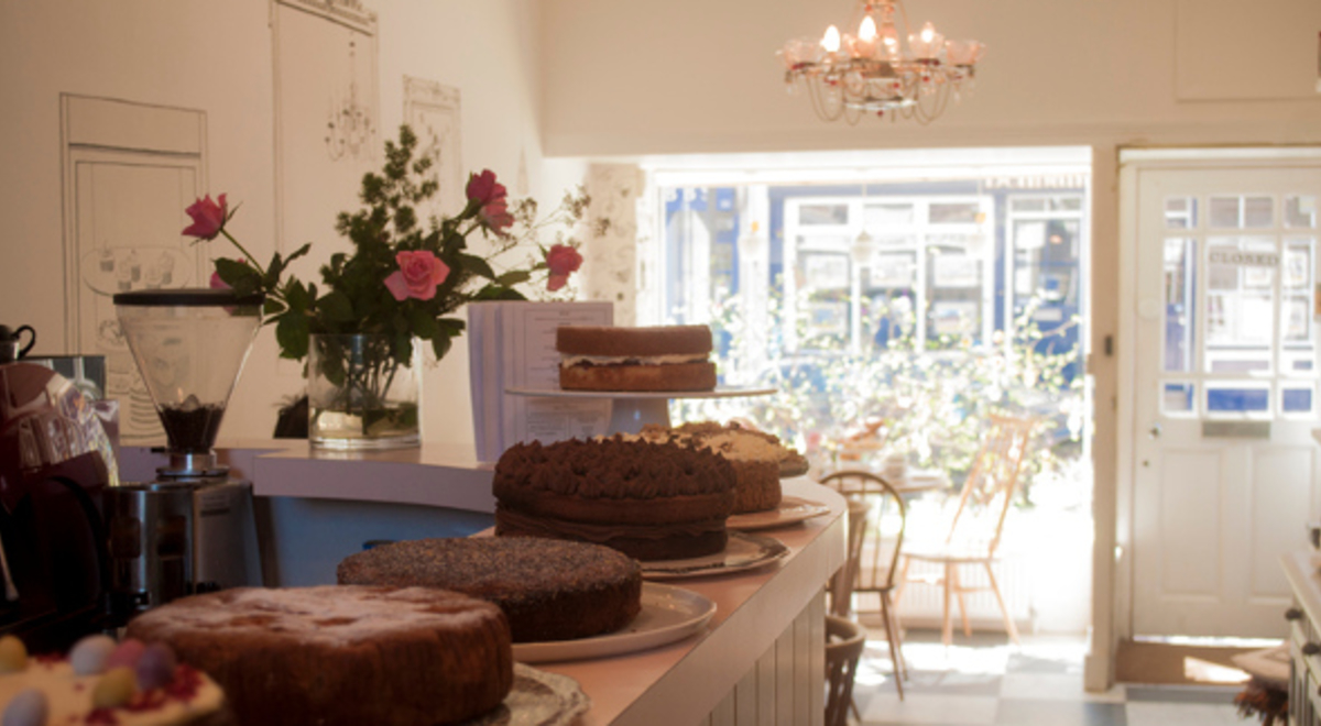 A beautiful cafe with assorted types of cake on the counter