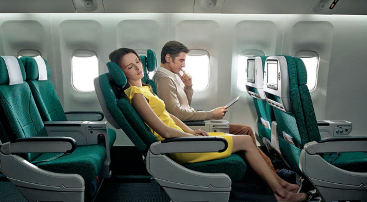 Lady relaxes with her seat reclined while a man reads next to her in flight