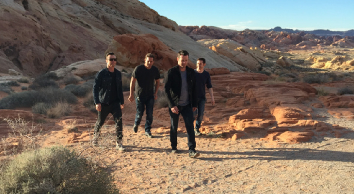Four men in black walking in Nevada desert