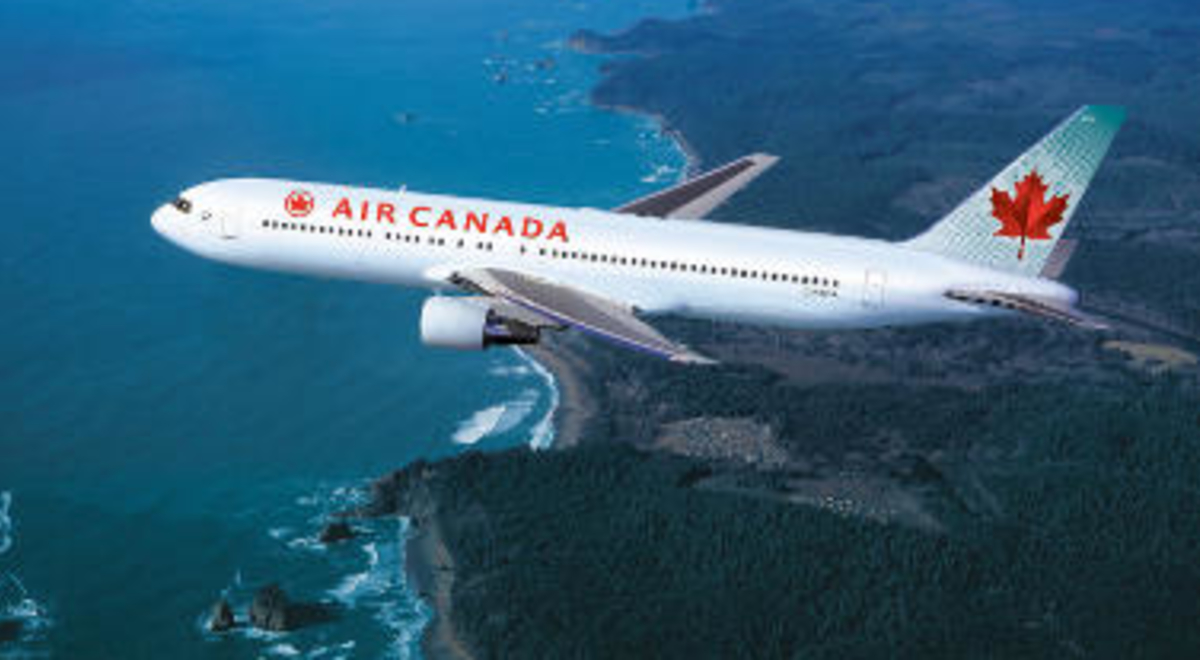 Air Canada plane flying over the ocean 