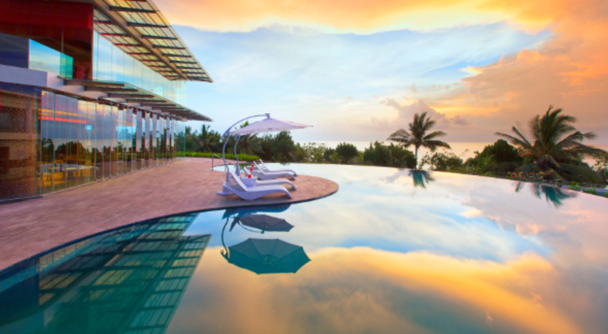 Glass house with an infinity pool that mirrors the sky