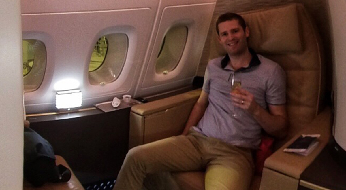 Couple holding a glass of champagne in their business class seat