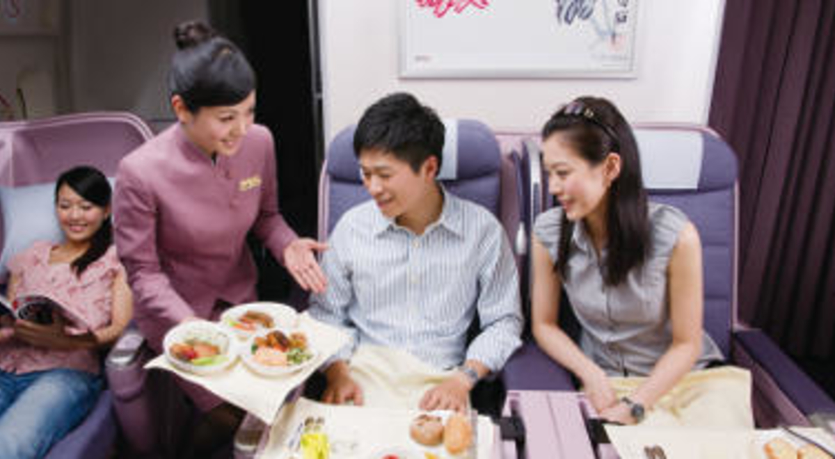 Flight attendant serving customers in China Airlines business class 