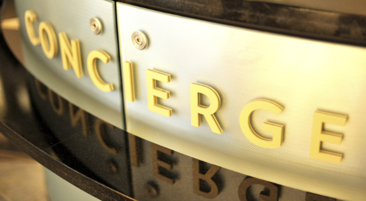 Golden concierge sign attached on a marble countertop
