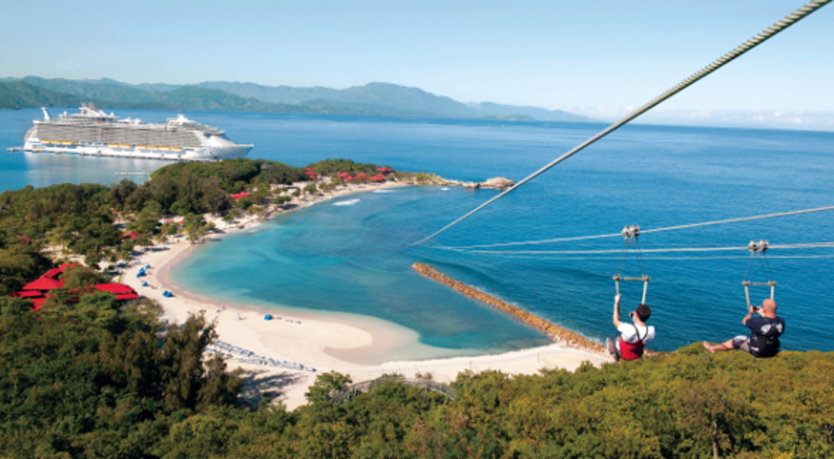 two tourist riding a zipline going down to the seashore 