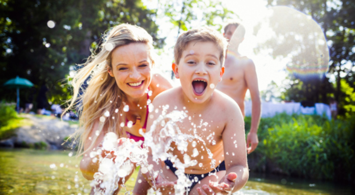 Family of three enjoying the water in their garden