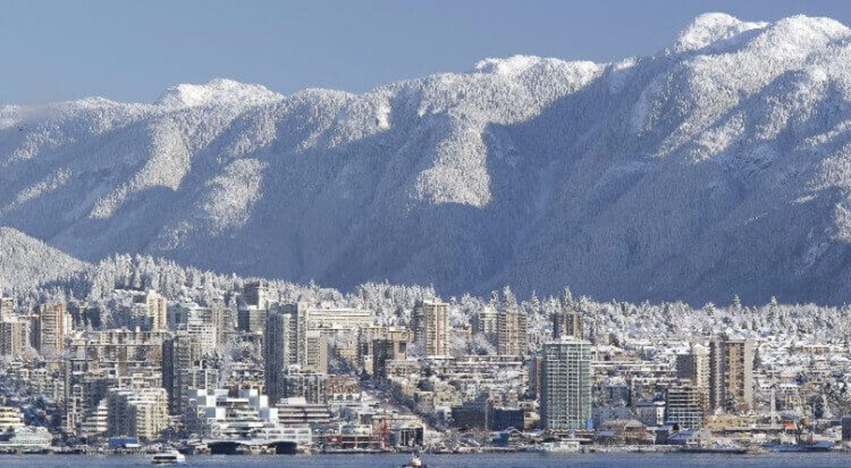 buildings entirely covered in snow and on the background is a white mountain