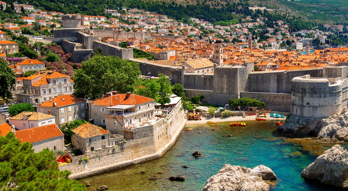 a view of the city of Croatia from a distance also featuring the wall of Dubrovnik