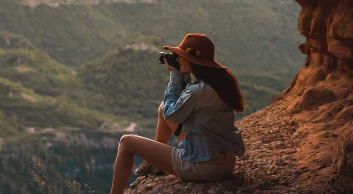 girl on mountain taking photo