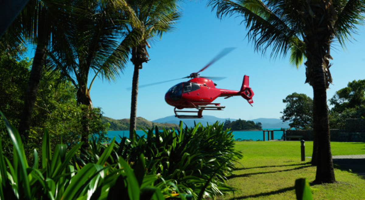 Helicopter landing on green grass at Hamilton Island 