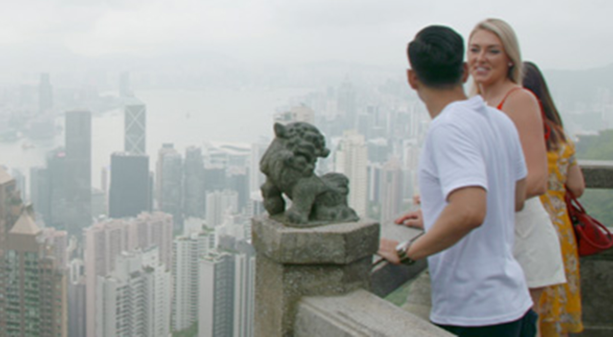 A male and female look at the view from Hong Kong's The Peak.