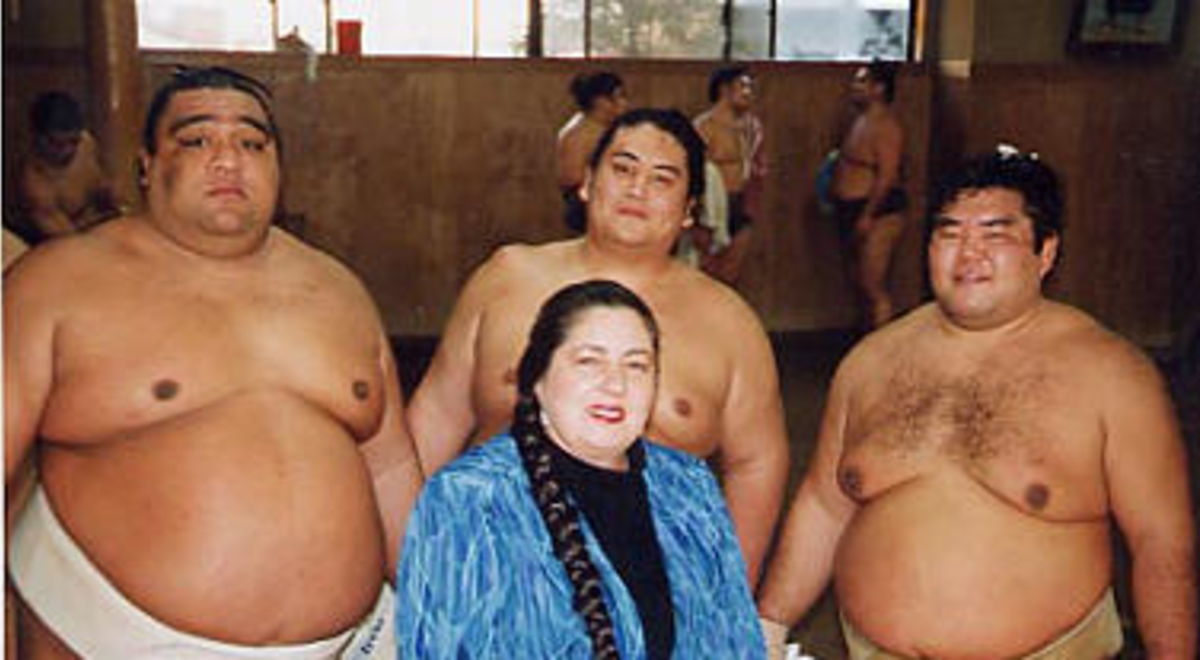 Katrina Watts posing with three sumo wrestlers 