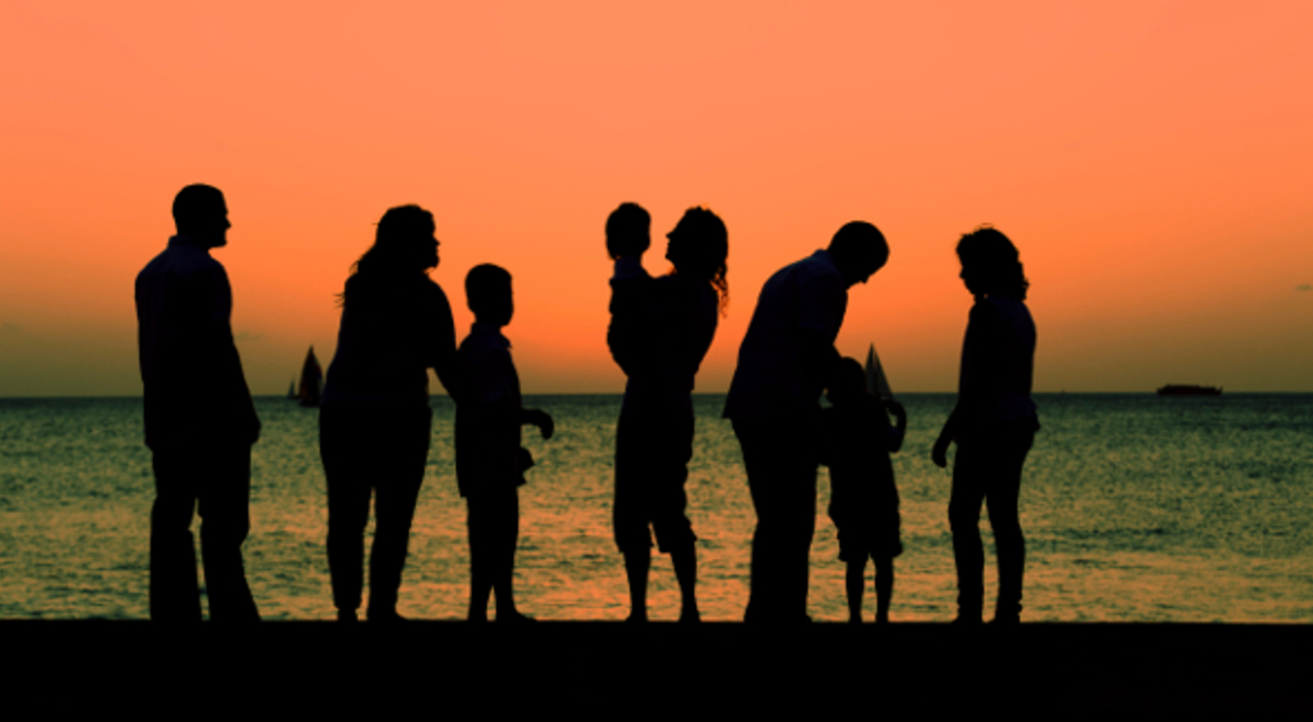 Silhouette of a family with the sunset and the ocean in the background