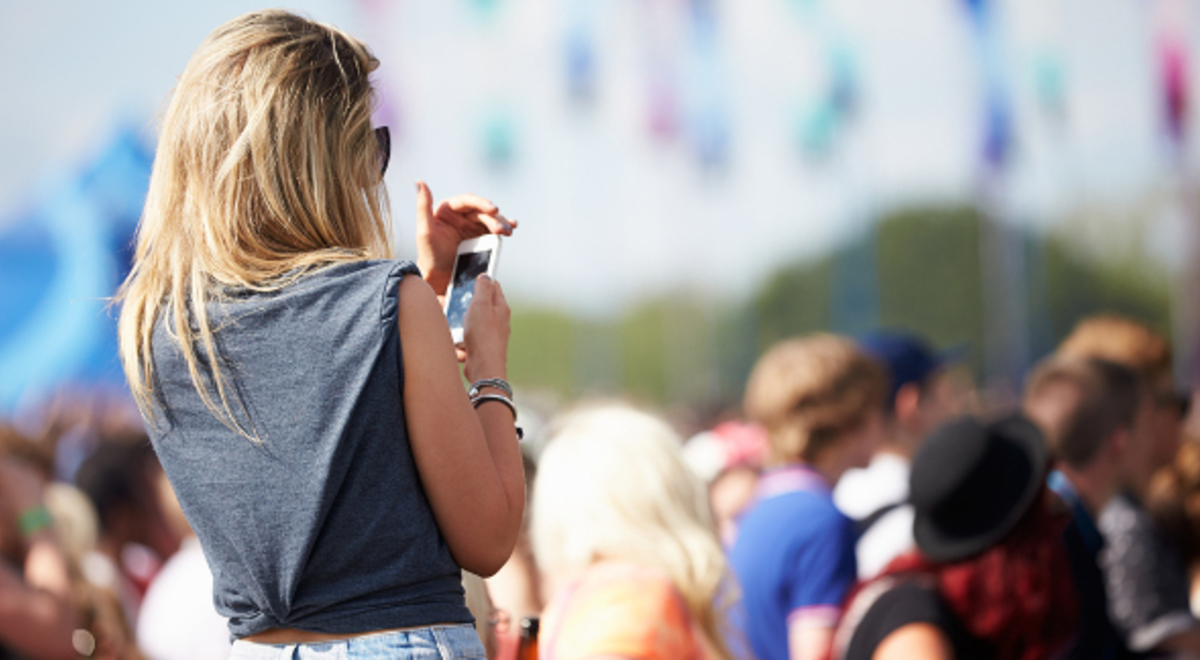 Lady in a crowd looking at her phone