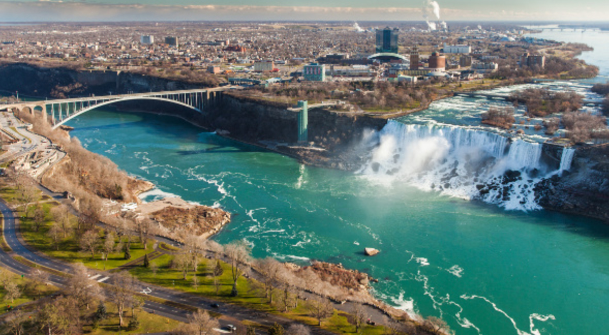 Full shot of Niagara Falls with the bridge and the city in the back