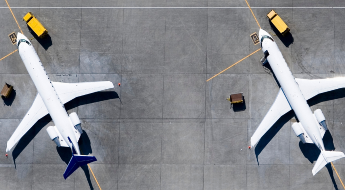 aerial view of three white airplanes parked at the airport