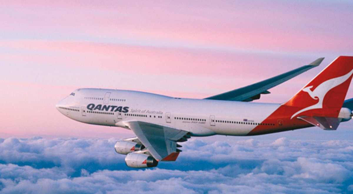Qantas airplane flying over the purple and blue horizon