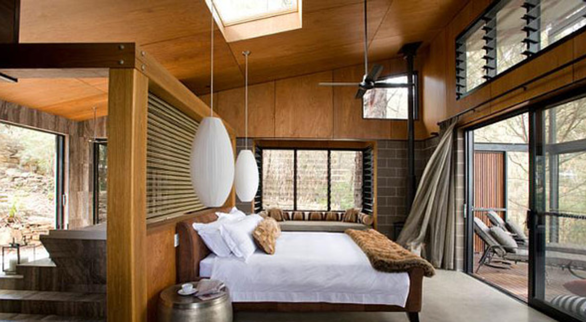 a wooden themed room with a white king sized bed and white cocoon-like hanging lamps