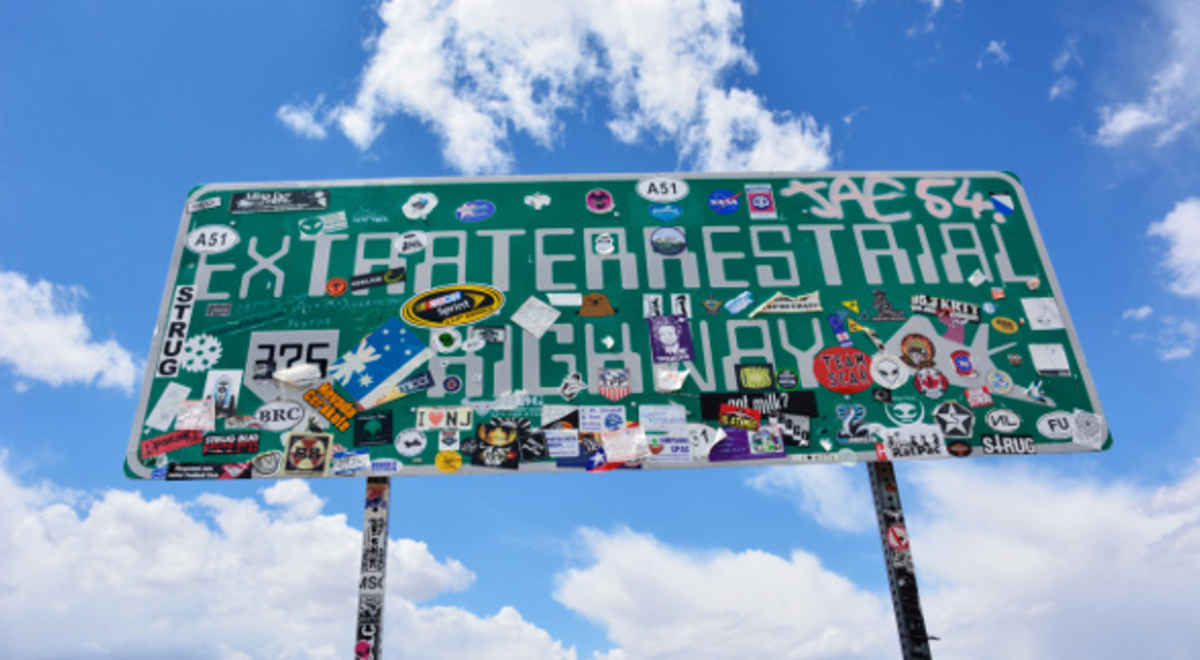 Extraterrestrial Highway sign with a lot of stickers on it