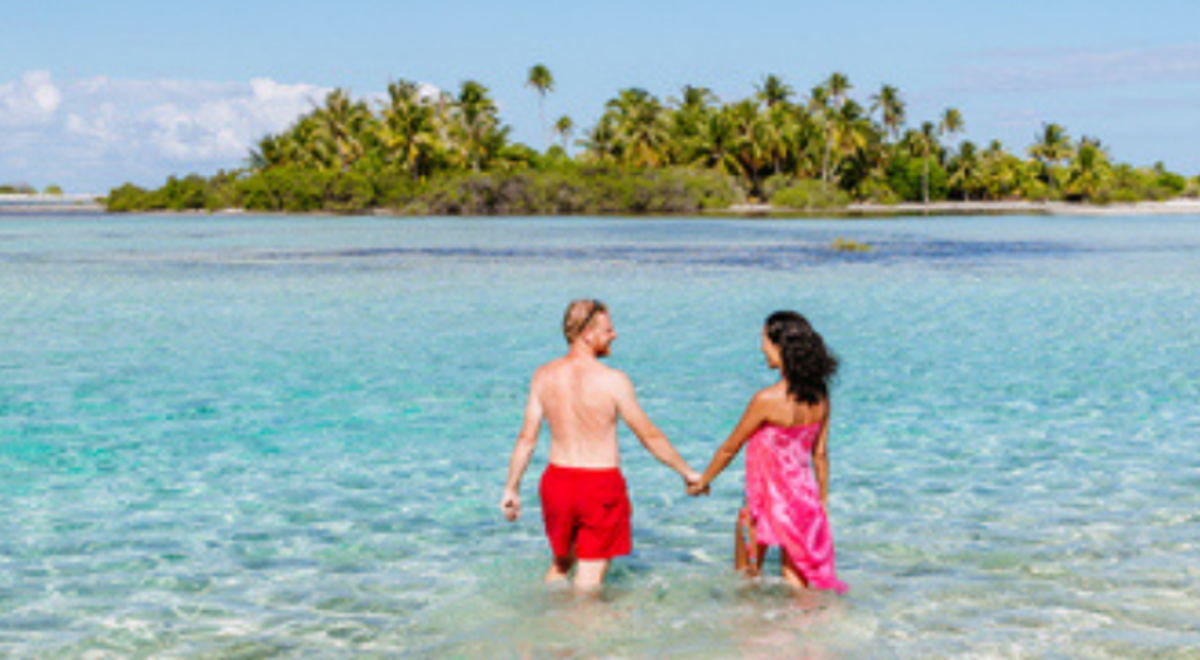 couple holding hands while standing in the middle of shallow water in Vanuatu