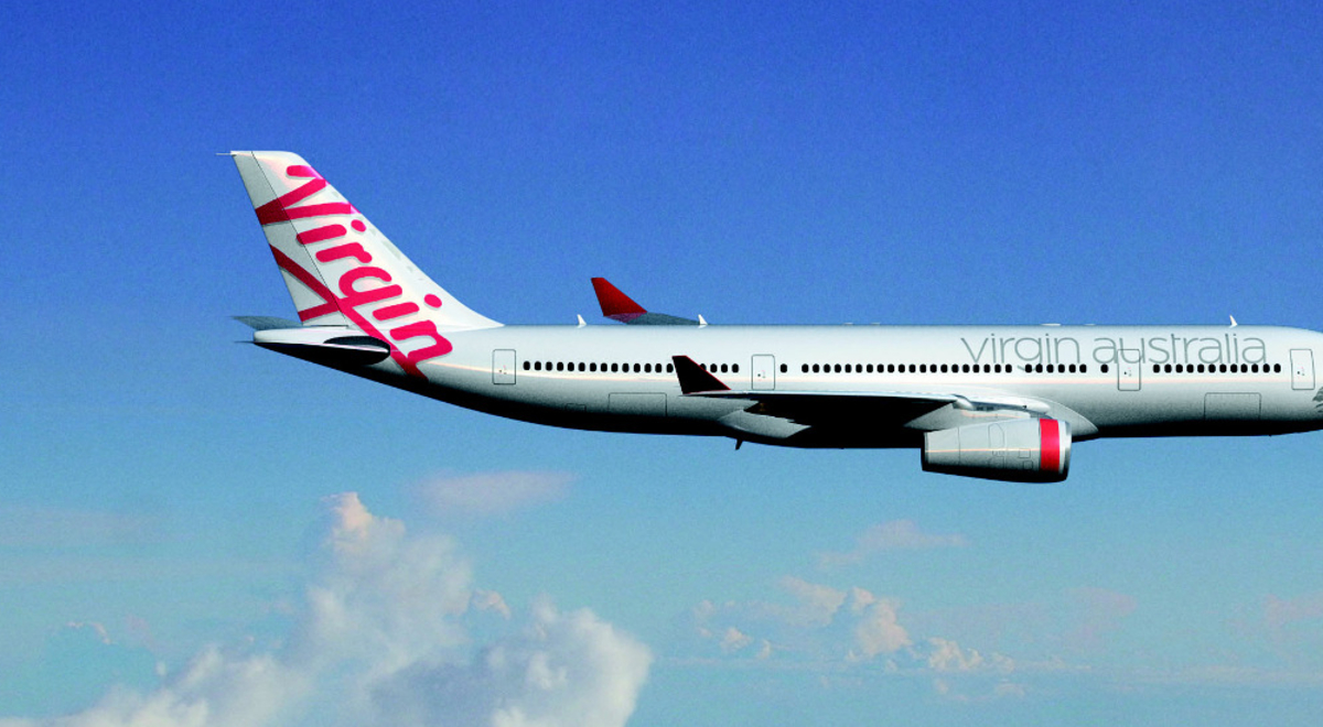 Virgin Australia airplane flying through blue skies with fluffy clouds in the background