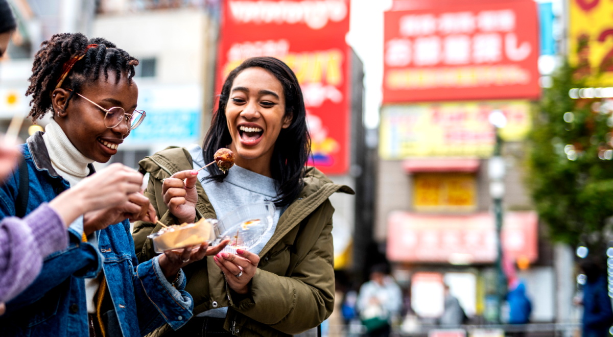 Travellers eating street food in Japan