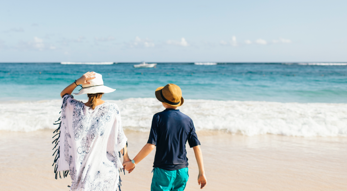 Mother and son holding hands on beach in the Caribbean