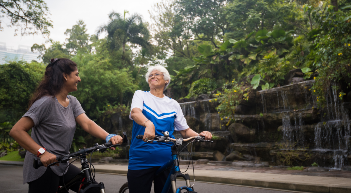 A senior-aged mother and her daughter cycling together in Kuala Lumpur