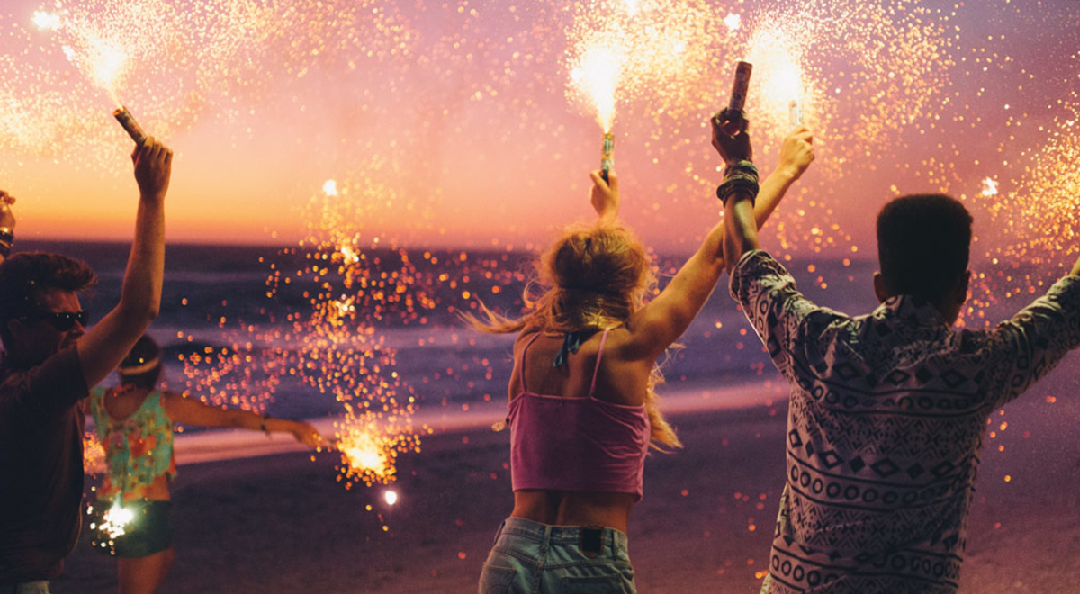 People partying with sparklers on a beach