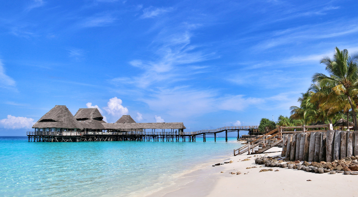 An azure lagoon with overwater bungalows by a white sandy beach