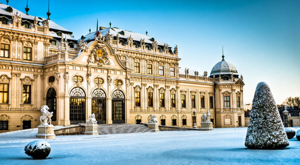 Large old building with a snowy front yard 