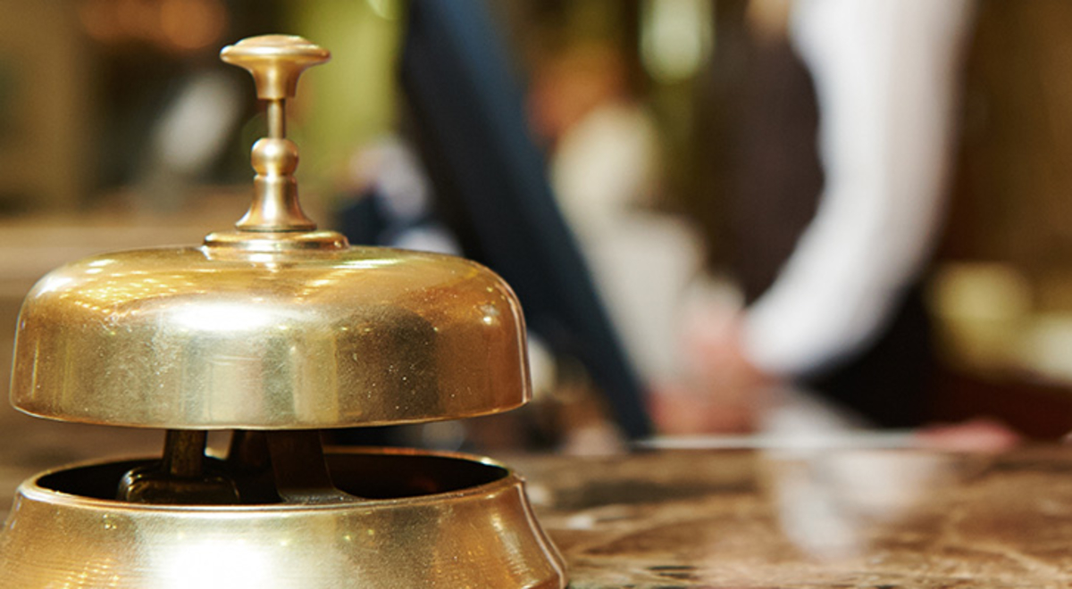 A bell sitting on a concierge desk in a hotel