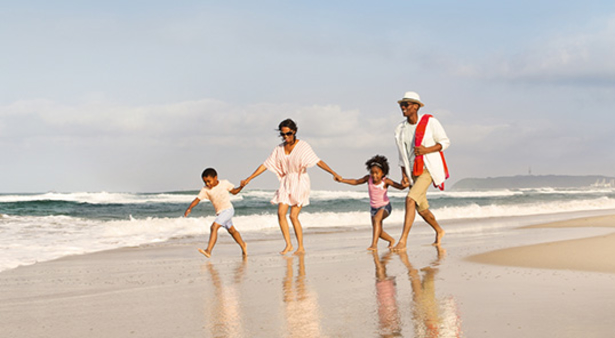 A young family playing on the beach and holding hands