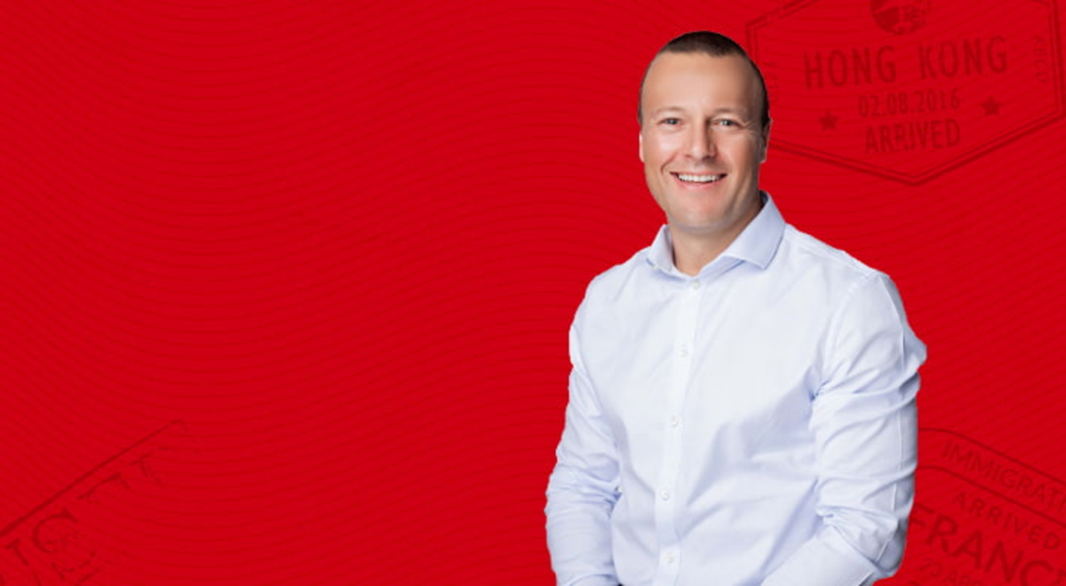 Man wearing white shirt in front of a red background