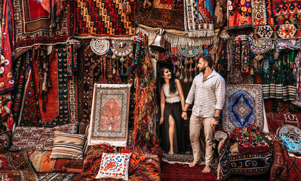 Couple smiling while browsing a carpet bazar in Istanbul