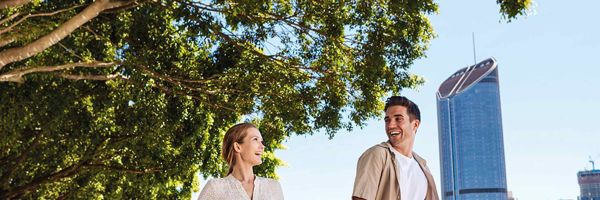 Couple smiling pushing bikes through South Bank in Queensland